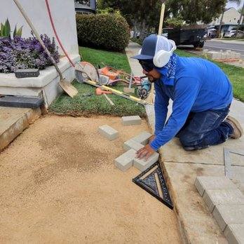 Craftsman laying pavers by hand